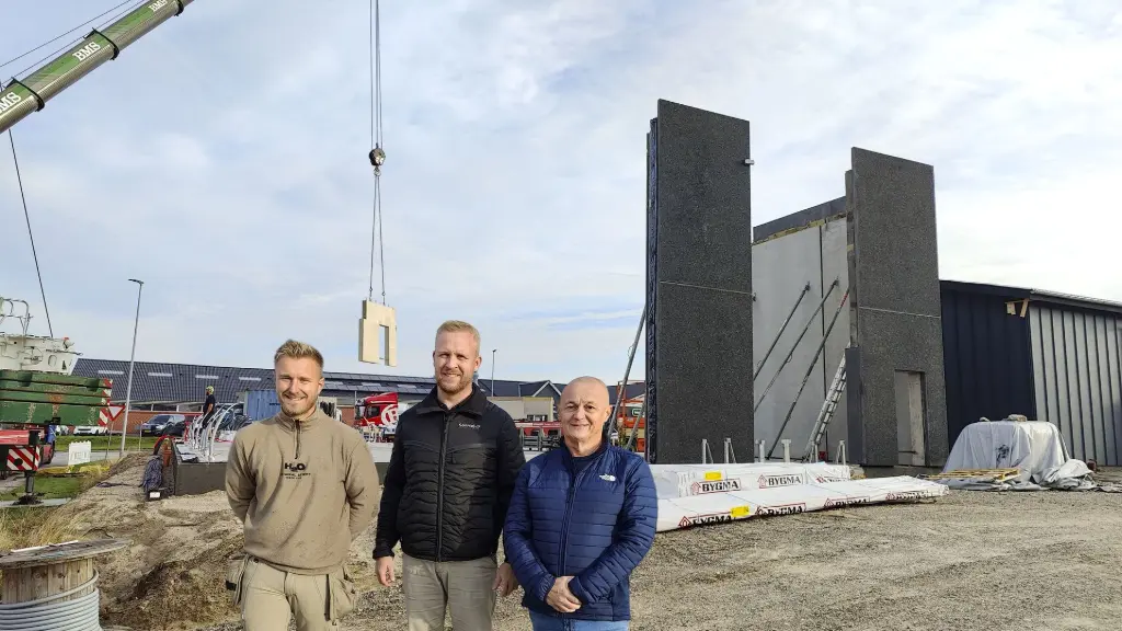 the building site where the walls are coming up, with the building entrepreneur and steen in front