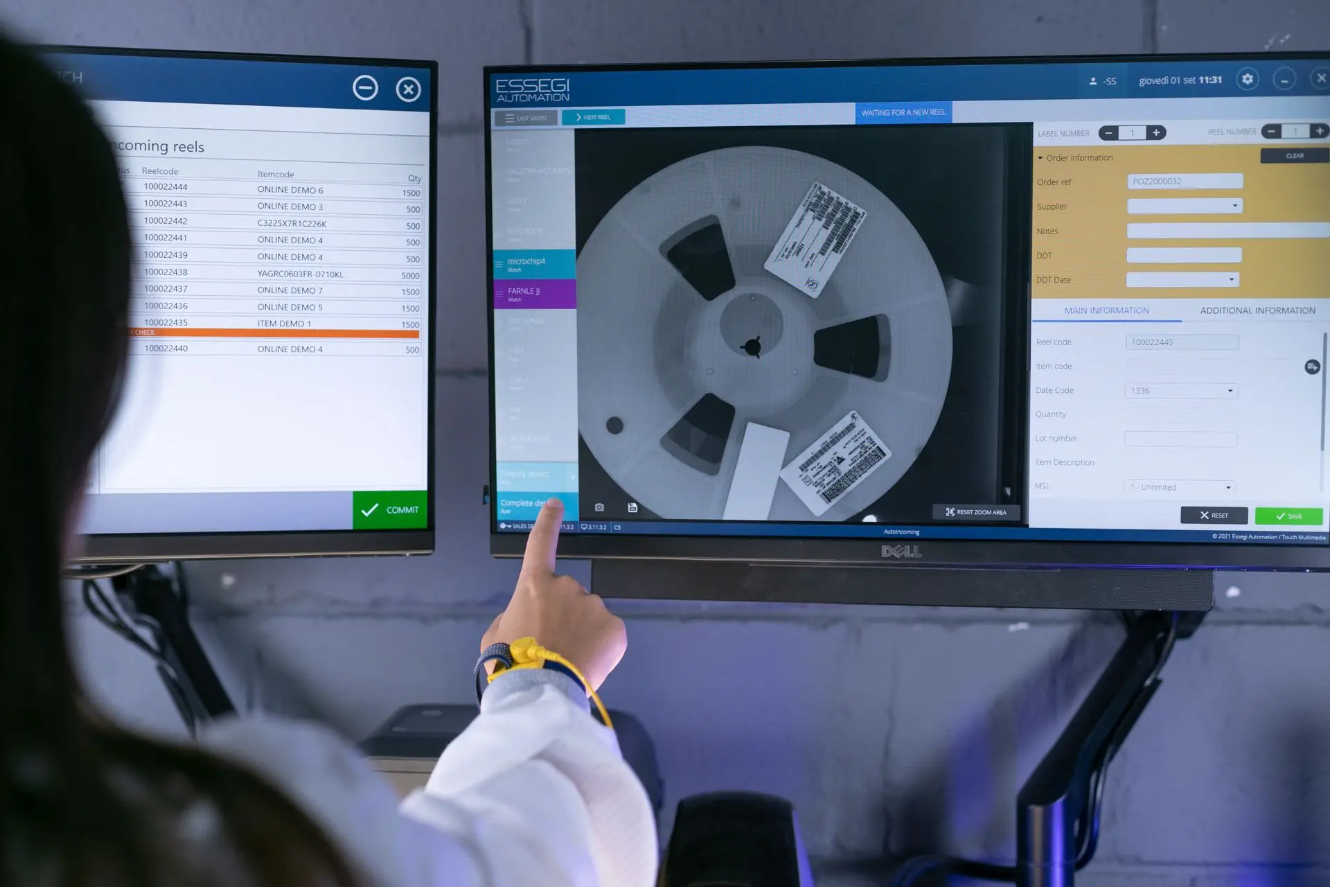 Person pointing at the incoming station screen to the SMD storage solution