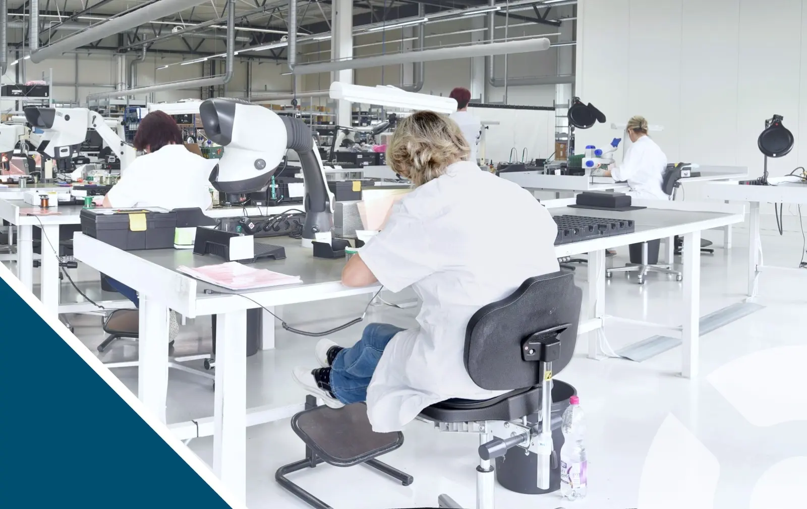 An electronics factory with many workers seated in a PCB inspection and PCB assembly by hand area